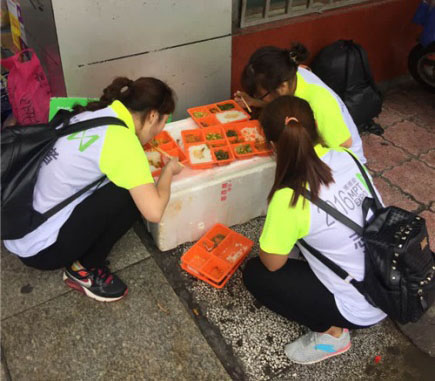 志愿者轮班值守，席地就餐对他们来说是家常便饭